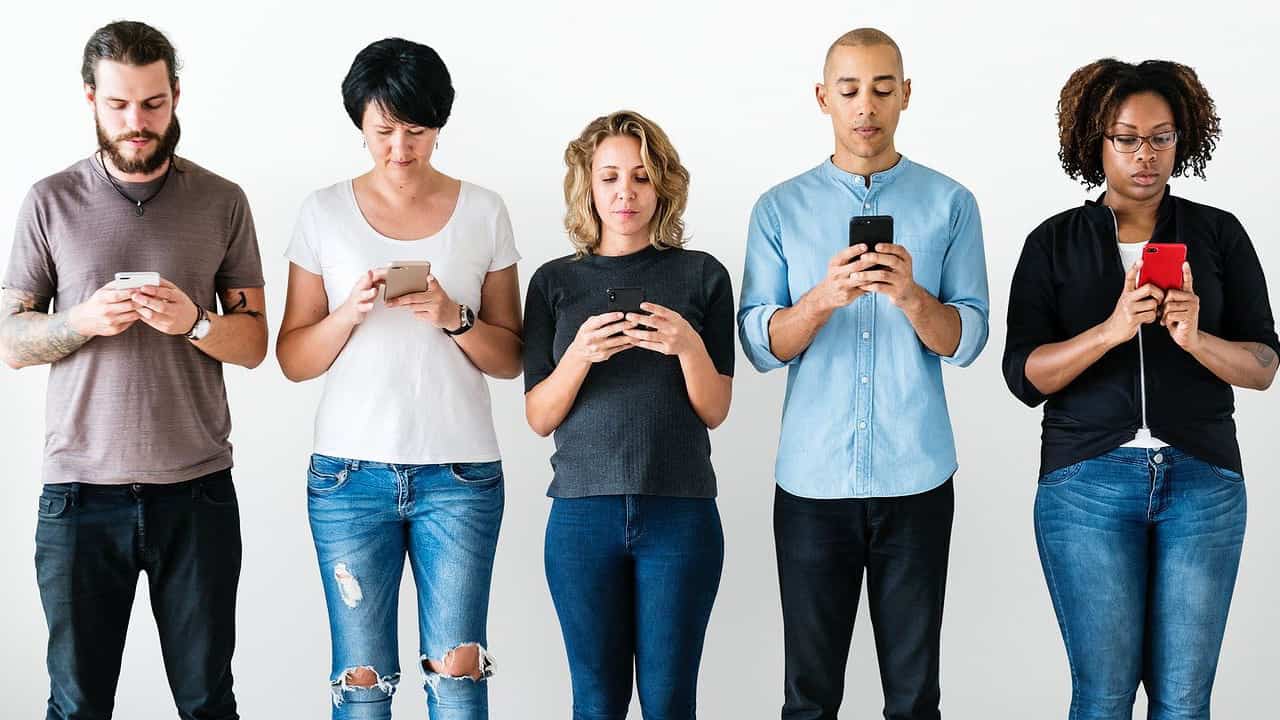 Group of young professionals looking at their cell phones.