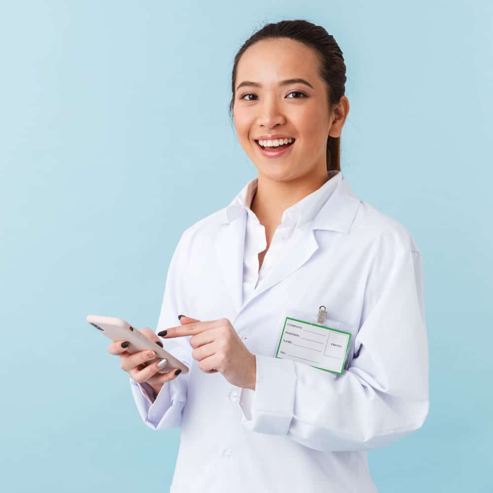 Young female doctor using her cell phone.