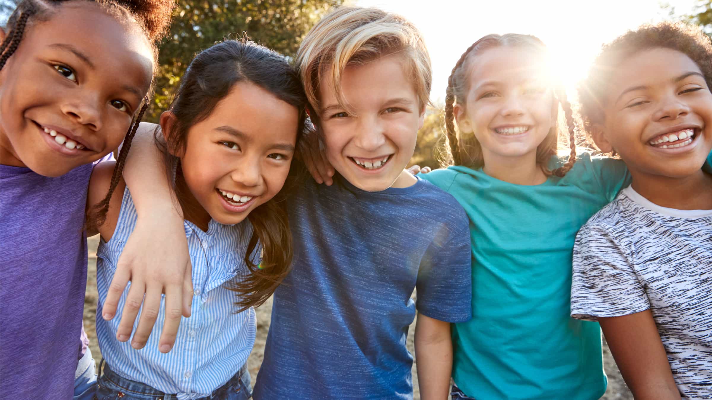 Set of kinds all smiling for a camera.