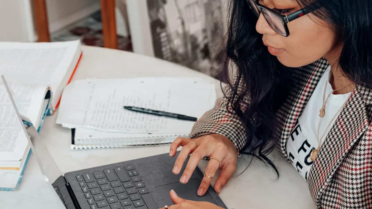 Young asian woman looking at laptop.