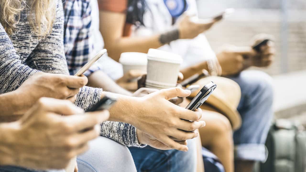 Group of young people looking at phones