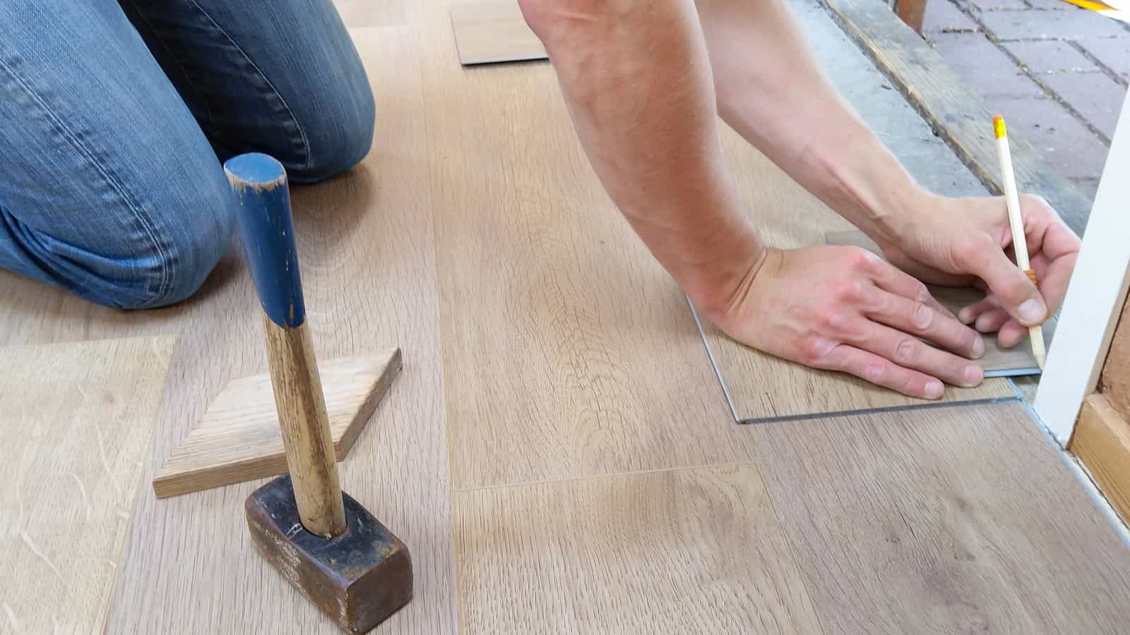 Man working on measuring a new floor after securing a home equity loan.