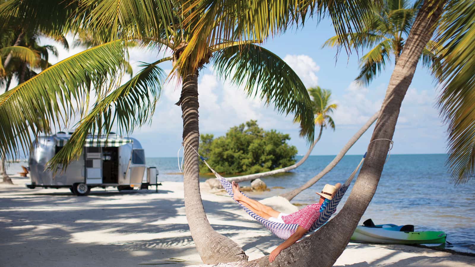 Retired person relaxin in a hammock near the beach.