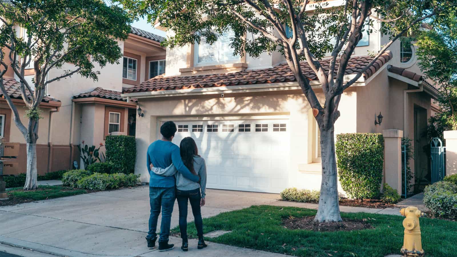 Young famlily standing outside their new home.