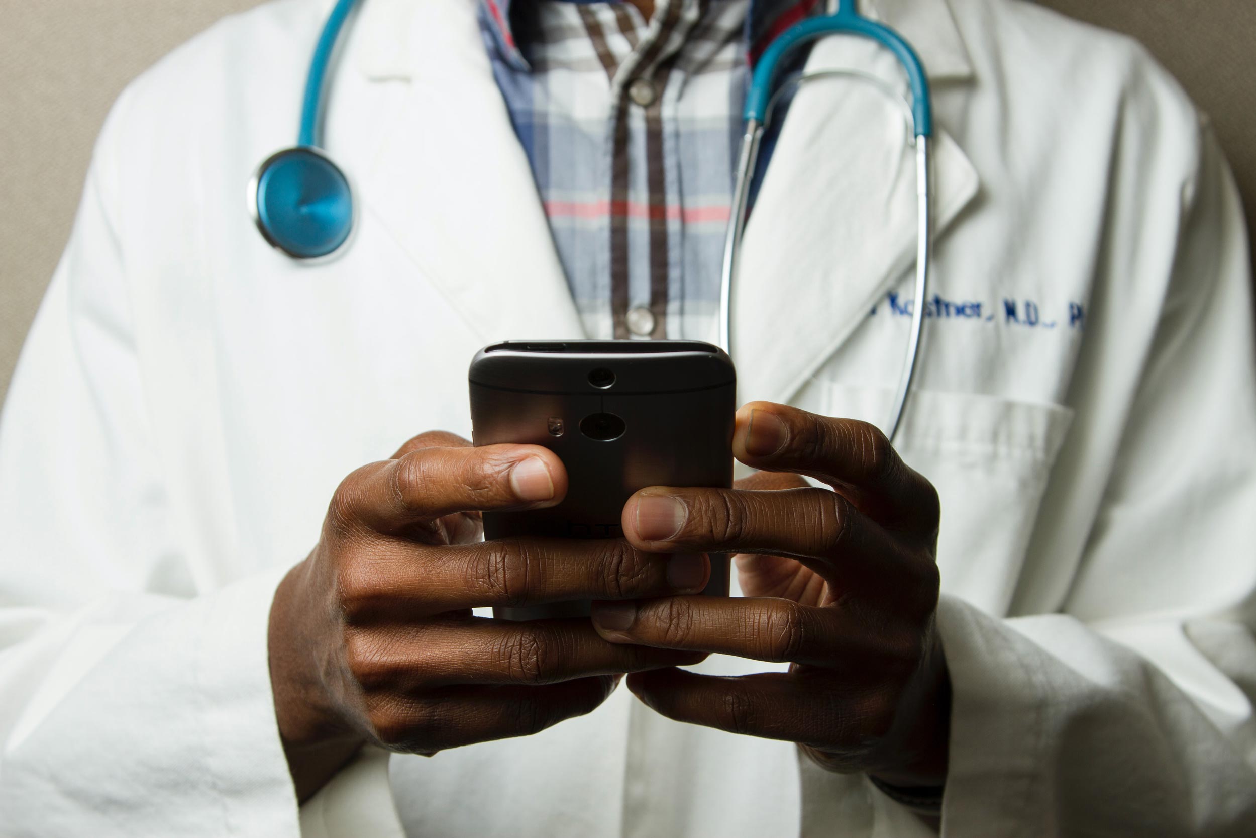Black Doctor using phone